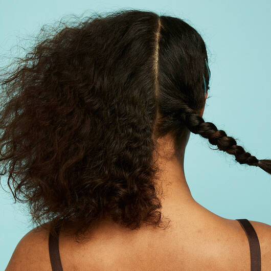 kvinde der står med sit hår efter hårpleje